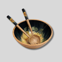 Navy blue mango wood salad servers with enamelled handles, featuring a sunflower and bee design, styled for outdoor dining.
