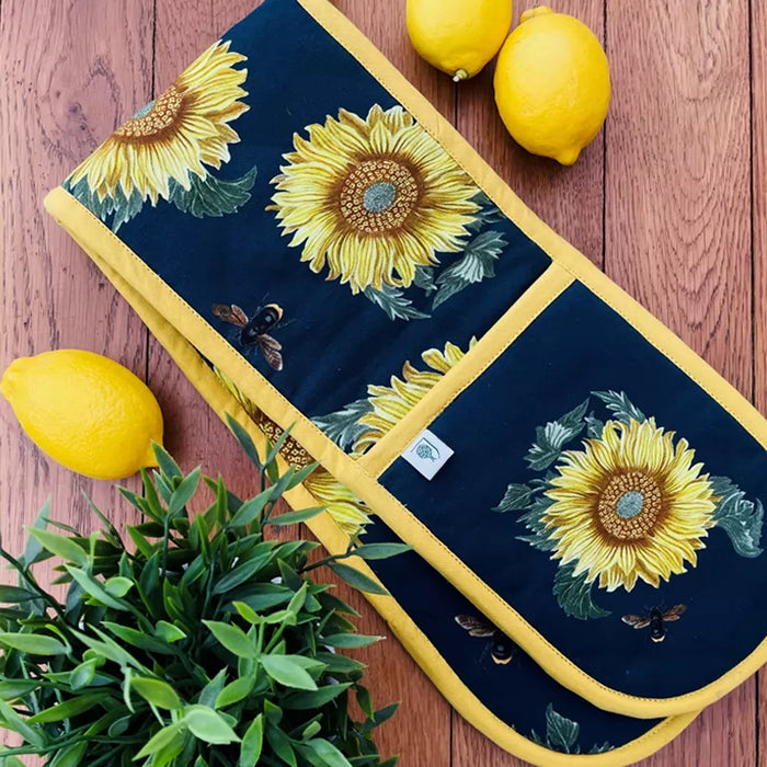Lifestyle image of Dexam X RHS's double oven gloves made from sustainable cotton, featuring a sunflower and bee design inspired by the RHS Lindley Collections.

